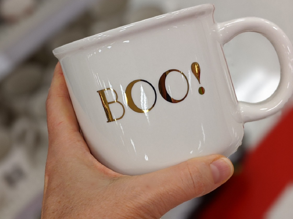 hand holding white mug that says Boo