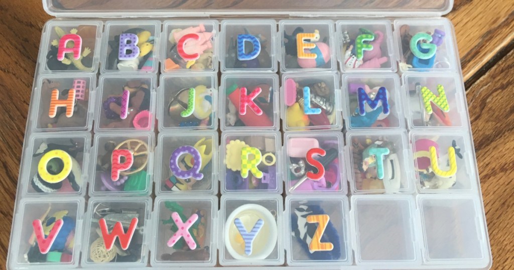 plastic box with letters on outside and little objects inside