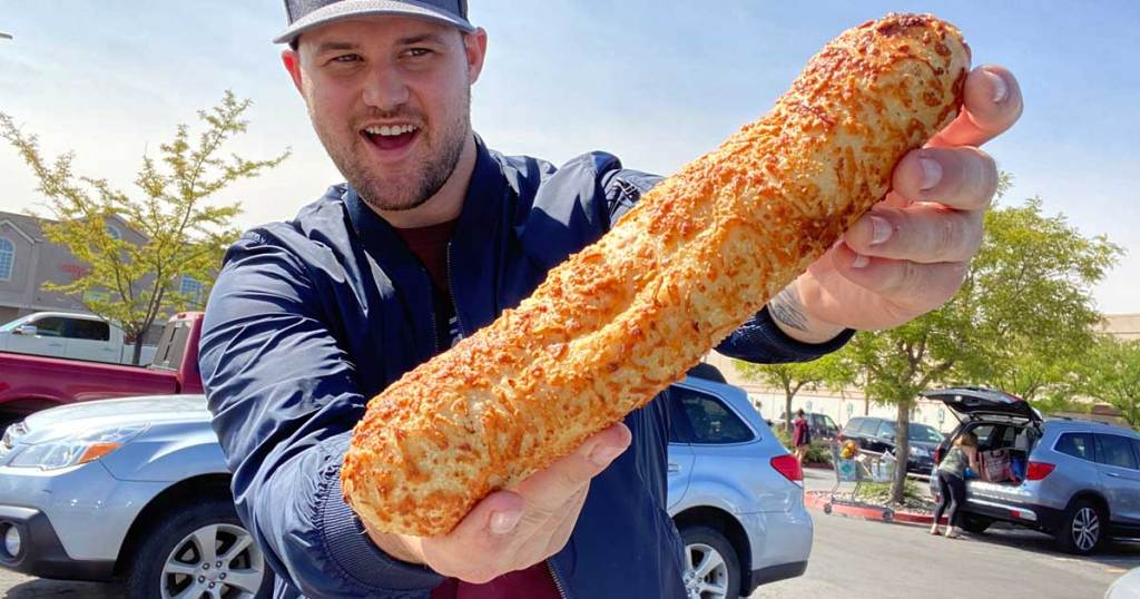 Man holding a large chicken bake in a parking lot