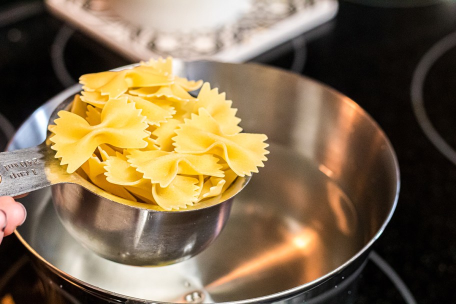 measuring cup of bowtie pasta noodles