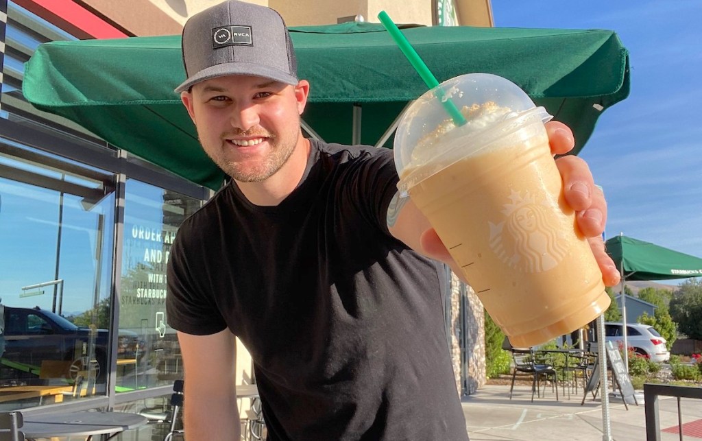 man holding a pumpkin cheesecake frappuccino