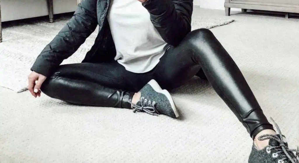 close up of woman wearing faux leather leggings in mirror
