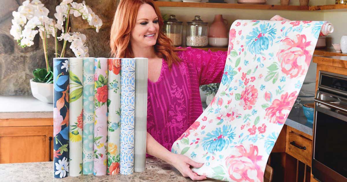 the pioneer woman holding a roll of wall paper