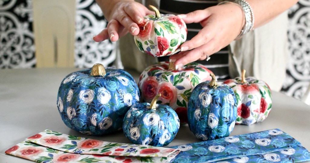 woman holding a group of dollar tree tissue pumpkins