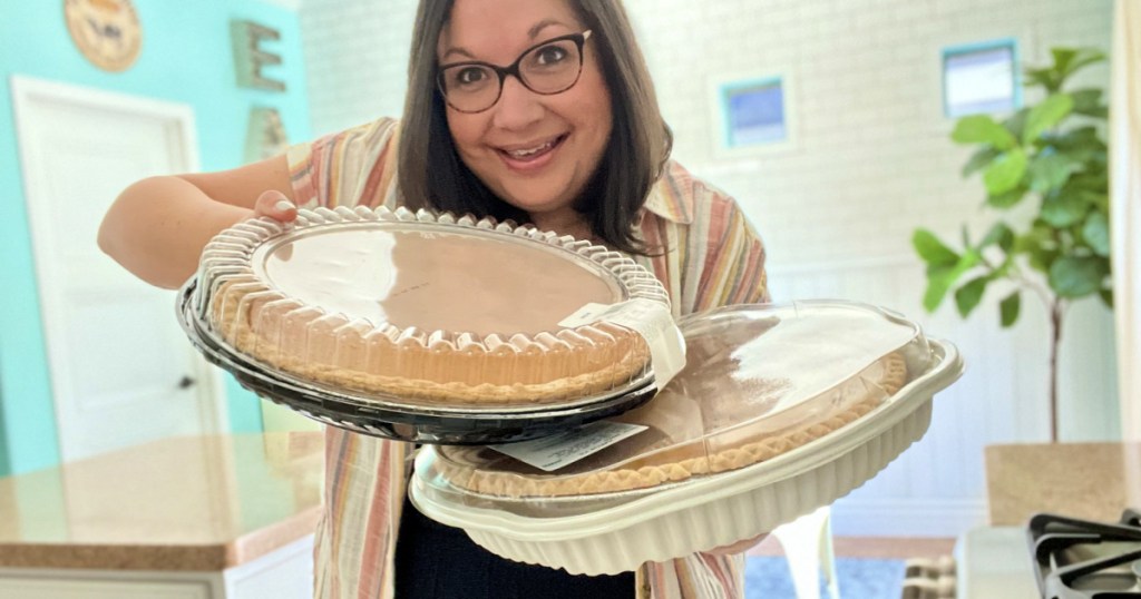 woman holding a sam's club pumpkin pie and costco pie