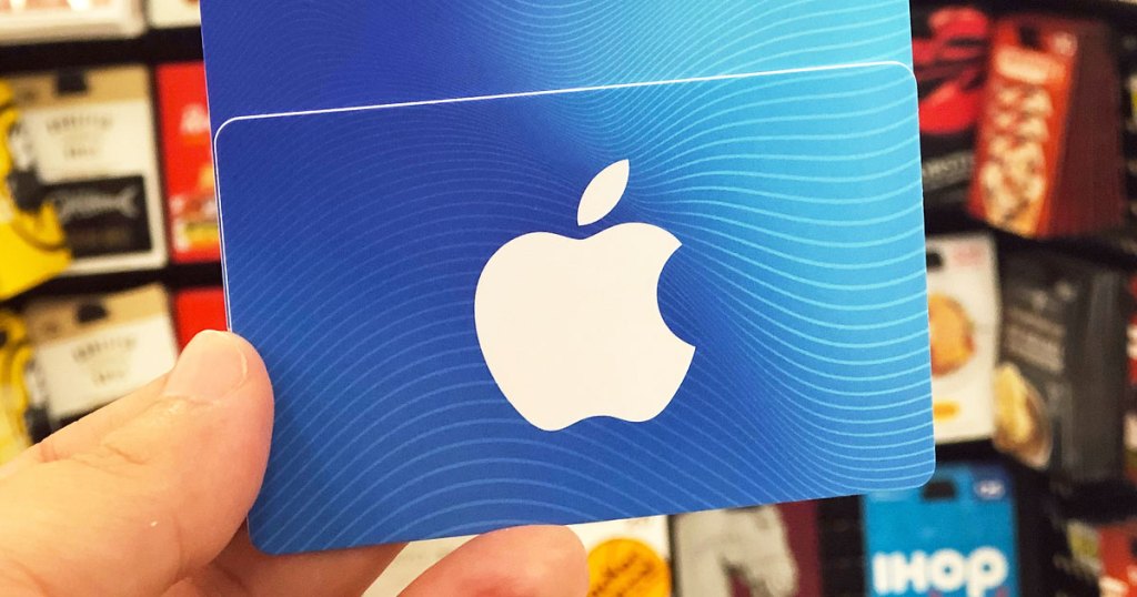 person holding up a white and blue apple gift card