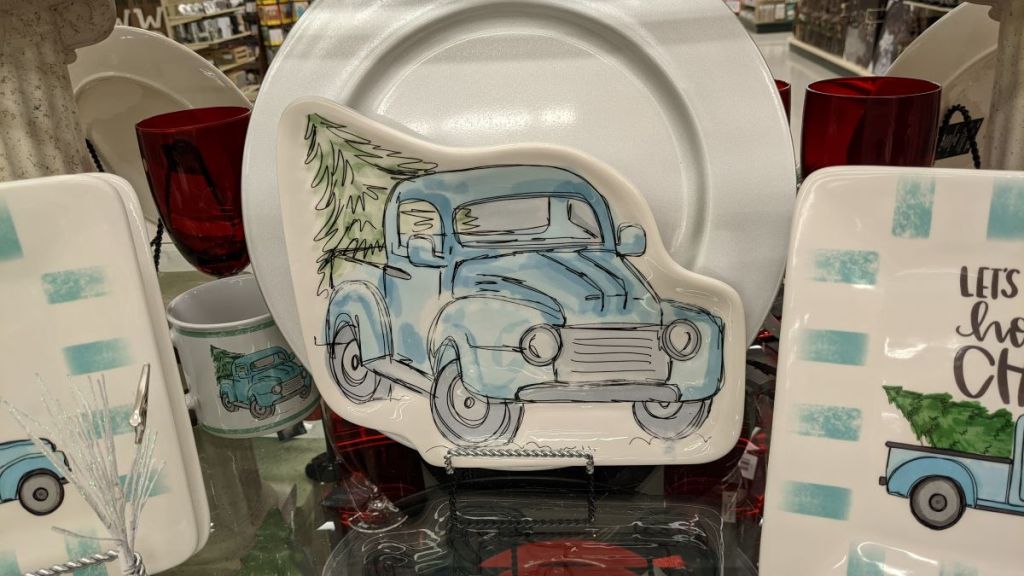plate with a blue truck carrying a tree in the back