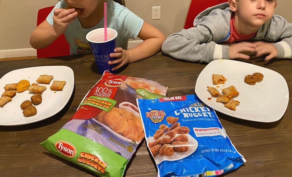 Two kids tasting different chicken nugget brands at a table