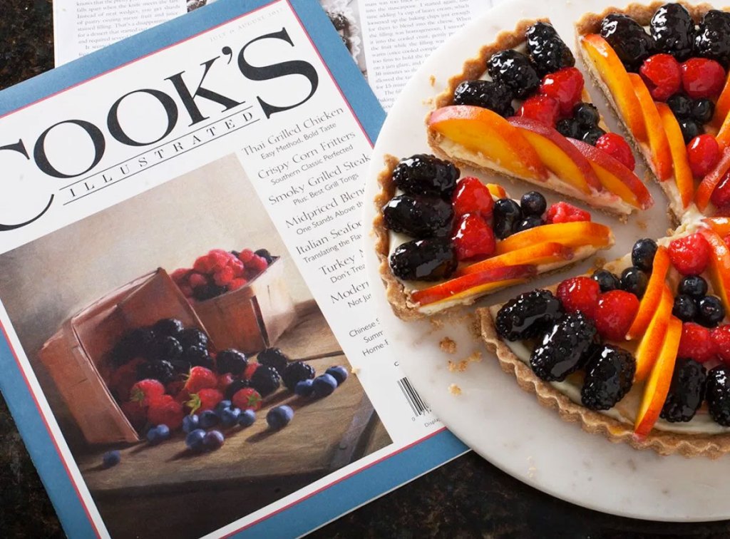 fruit tart on white plate on top of an issue of cooks illustrated magazine