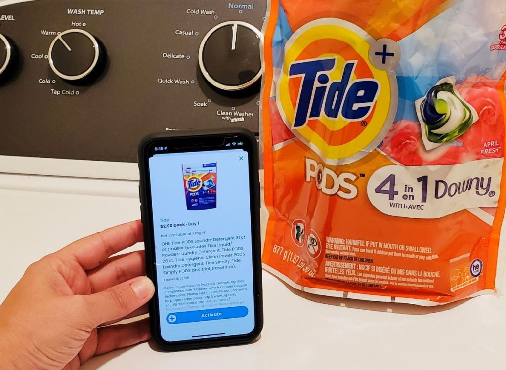 hand holding a phone next to a bag of Tide pods