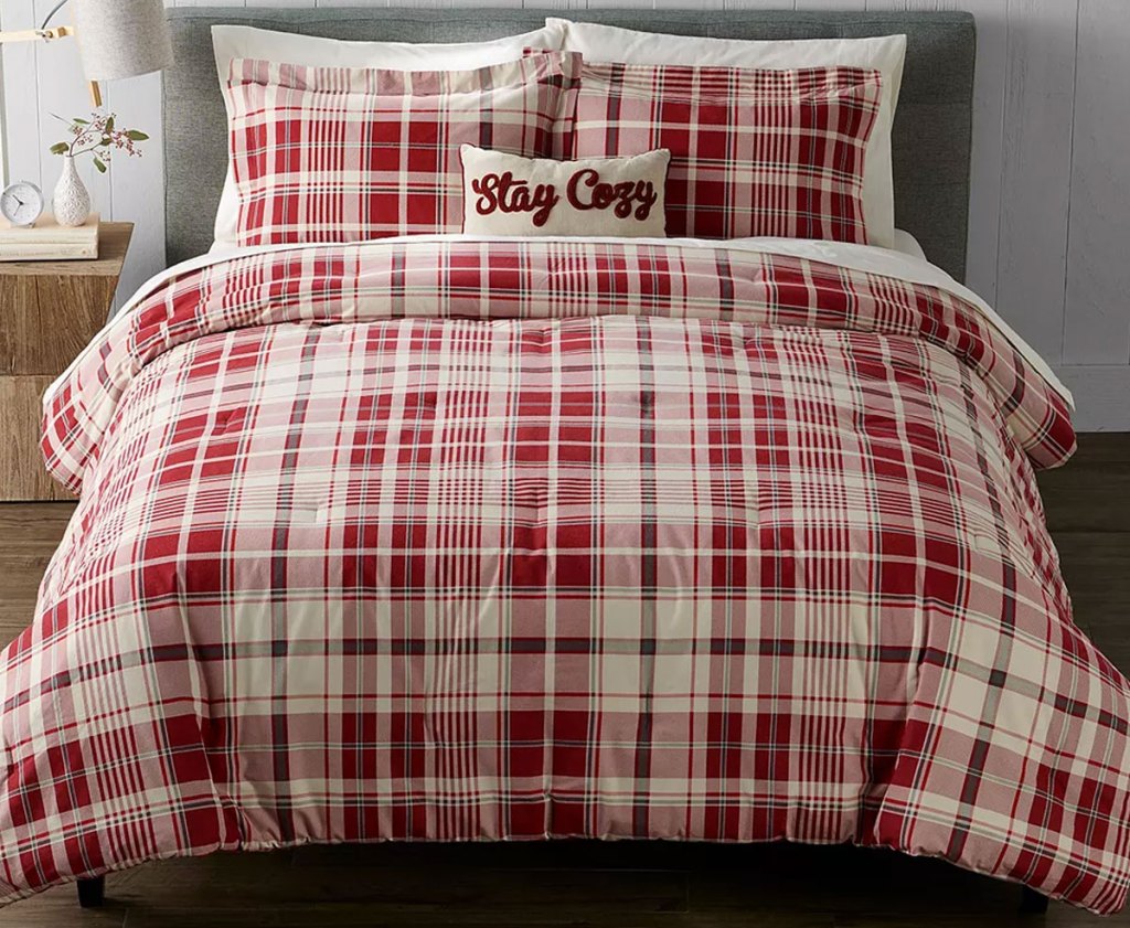 red and white plaid comforter set on bed with matching throw pillow that says stay cozy