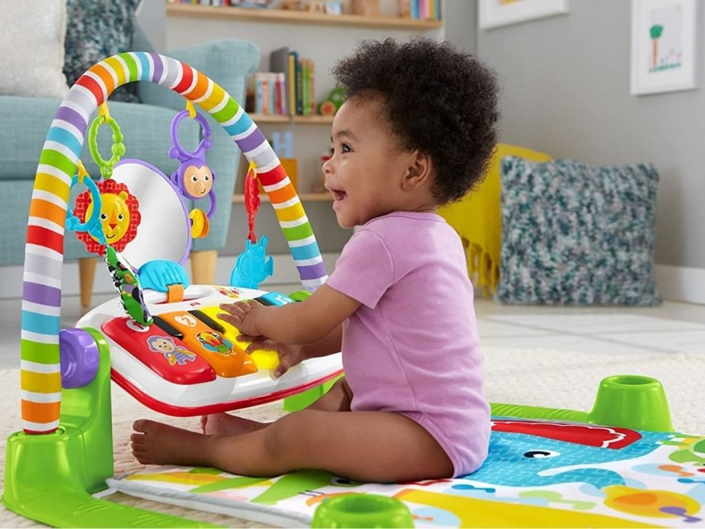 Fisher Price Kick and Play Piano with little girl sitting up playing with it