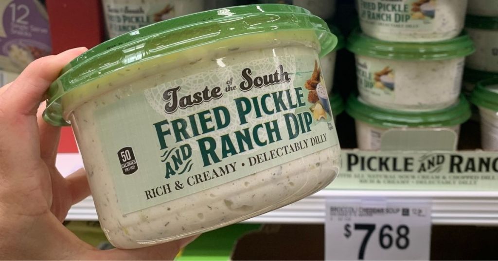 hand holding a container of pickle dip