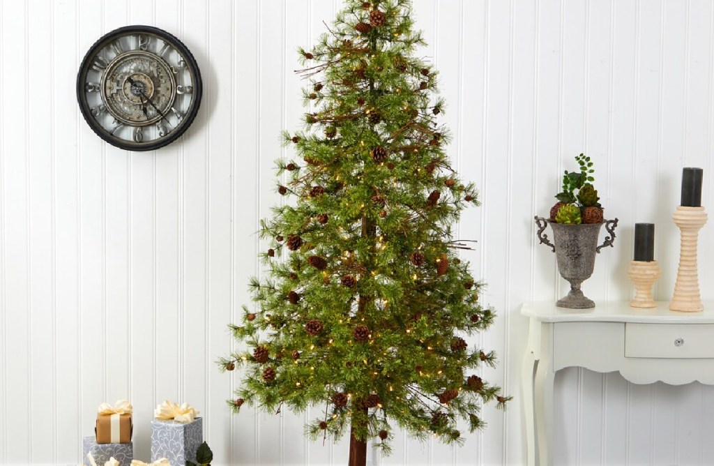 skinny tall christmas tree with small pinecones in a living space