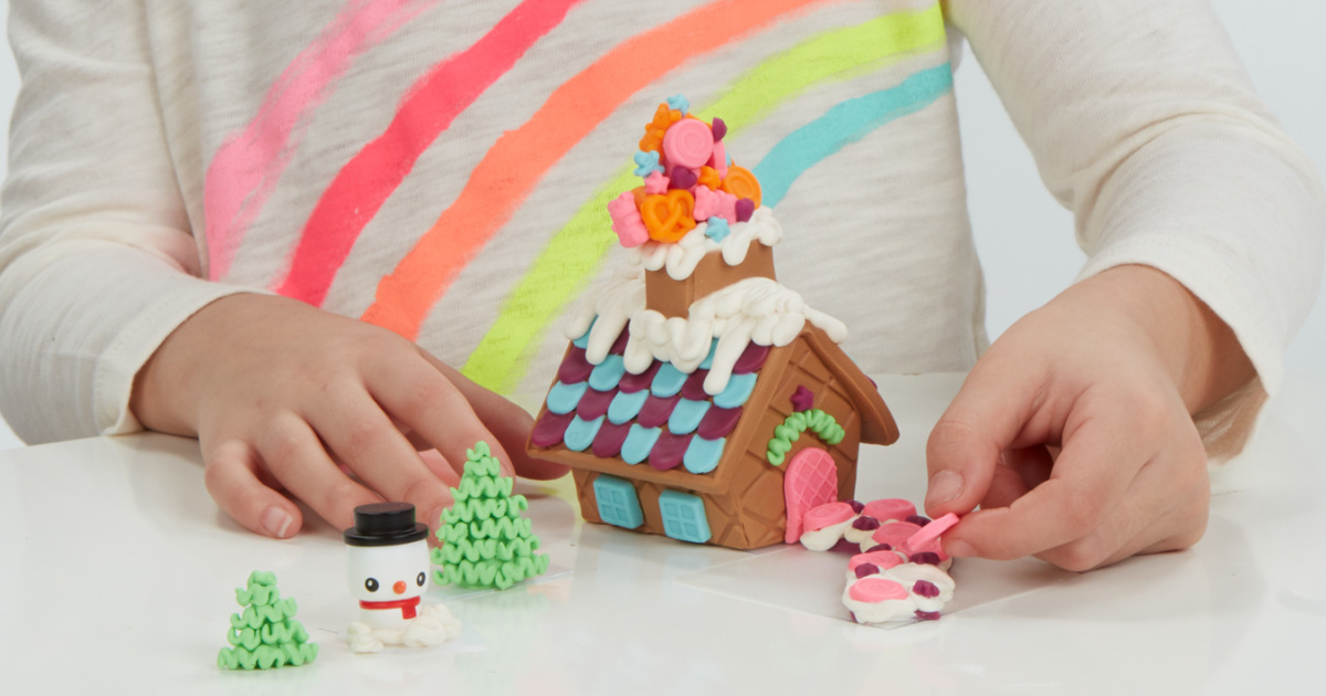 little girl playing with a Play-Doh Gingerbread House kit