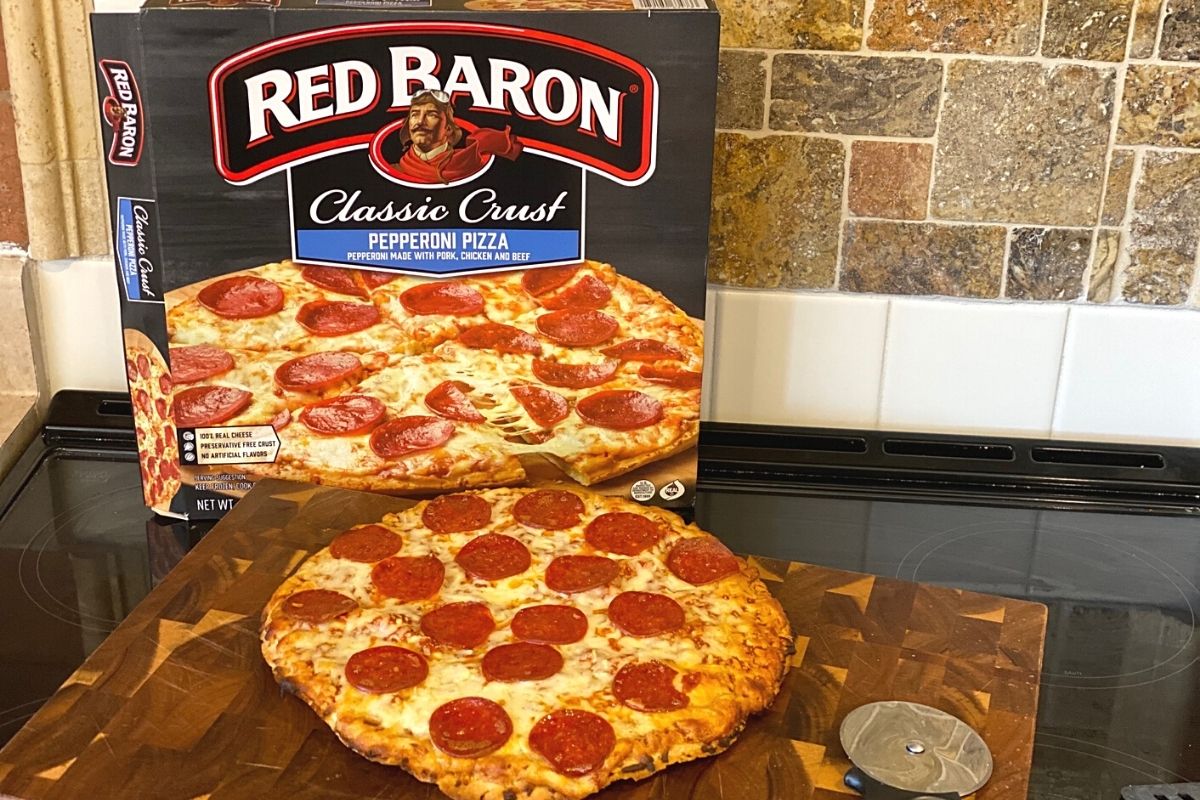 red baron pizza next to the box on a stove