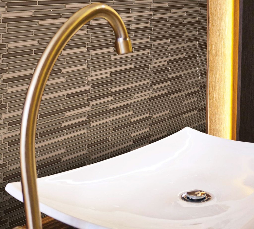 neutral and brown peel and stick wall tiles behind bathroom sink