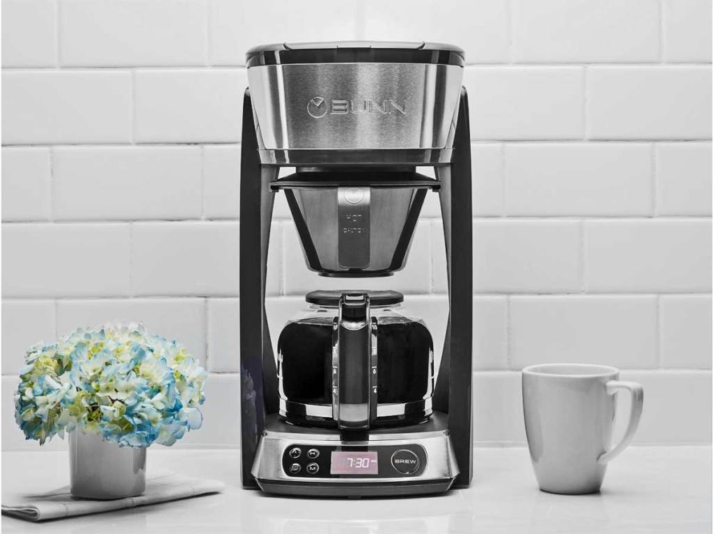 coffeemaker on counter next to coffee cup