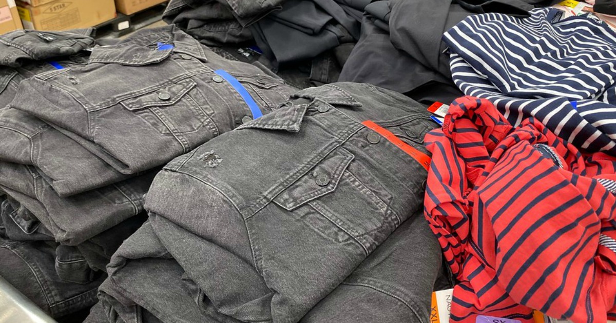 stacks of denim jackets and shirts on a table