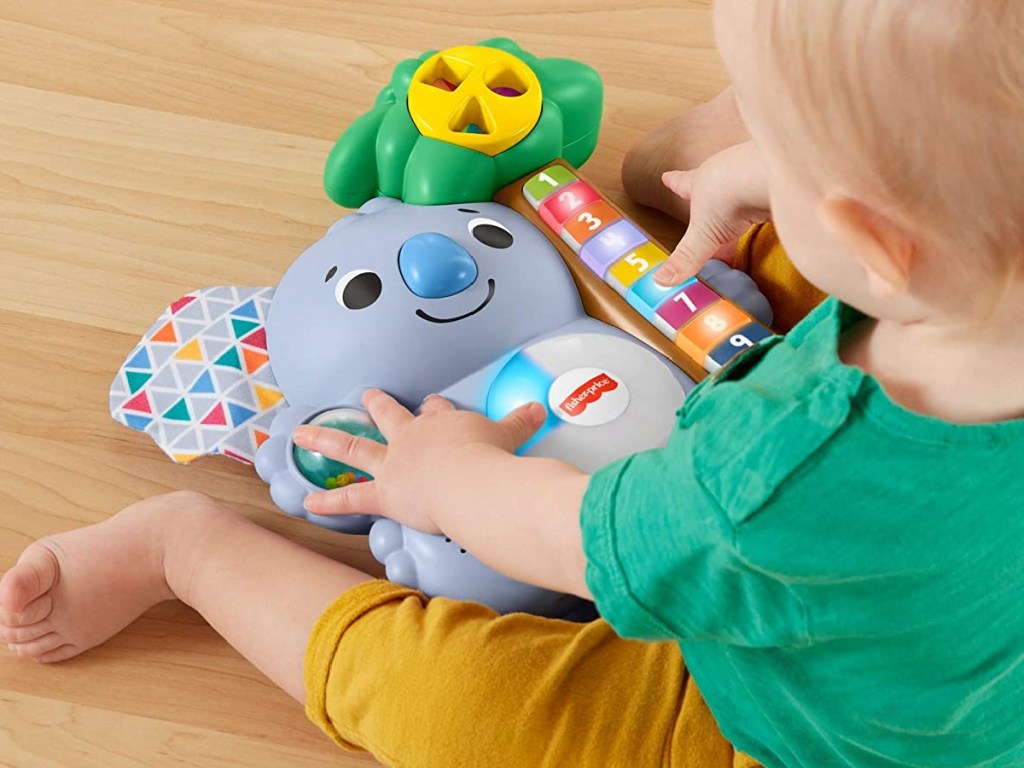 baby playing with little toy shaped like a koala