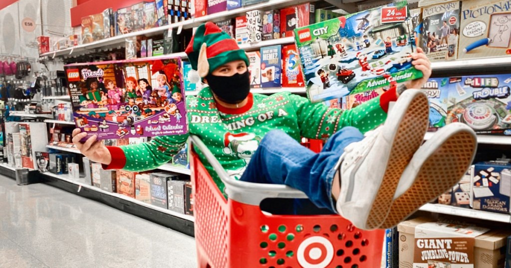 man in shopping cart holding LEGO toys at Target