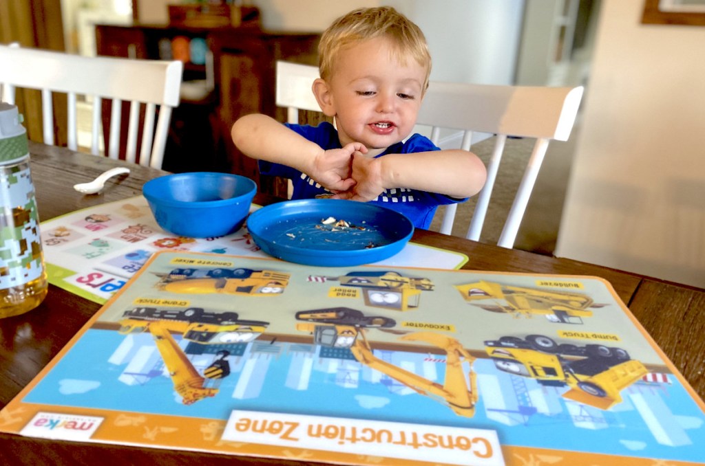 boy sitting at table with blue dishes on table