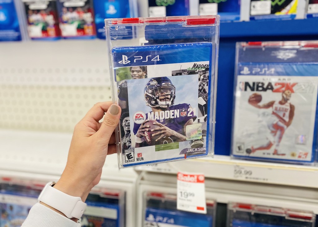 hand holding ps4 madden game on store shelf
