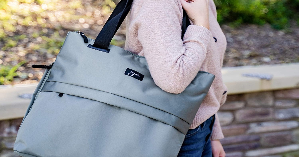 woman outside in a pink shirt with a grey tote bag on her shoulder