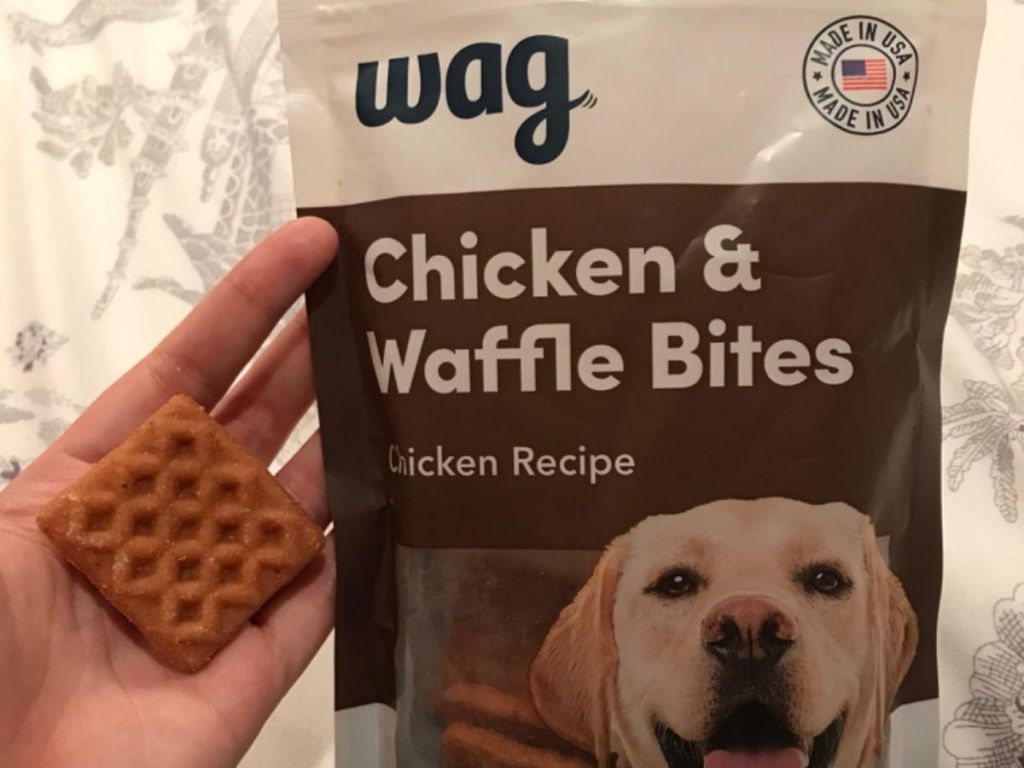 hand holding wag chicken and waffle bite in front of bag 