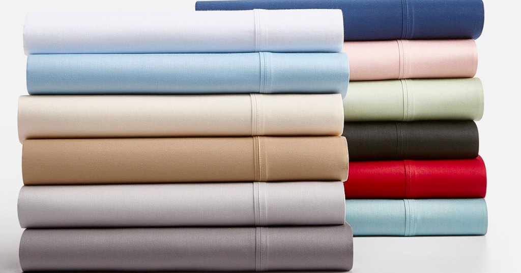two piles of folded sheets in various solid colors