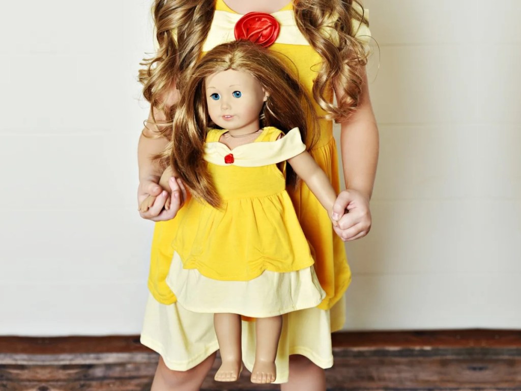 girl in Belle princess dress holding doll in matching dress