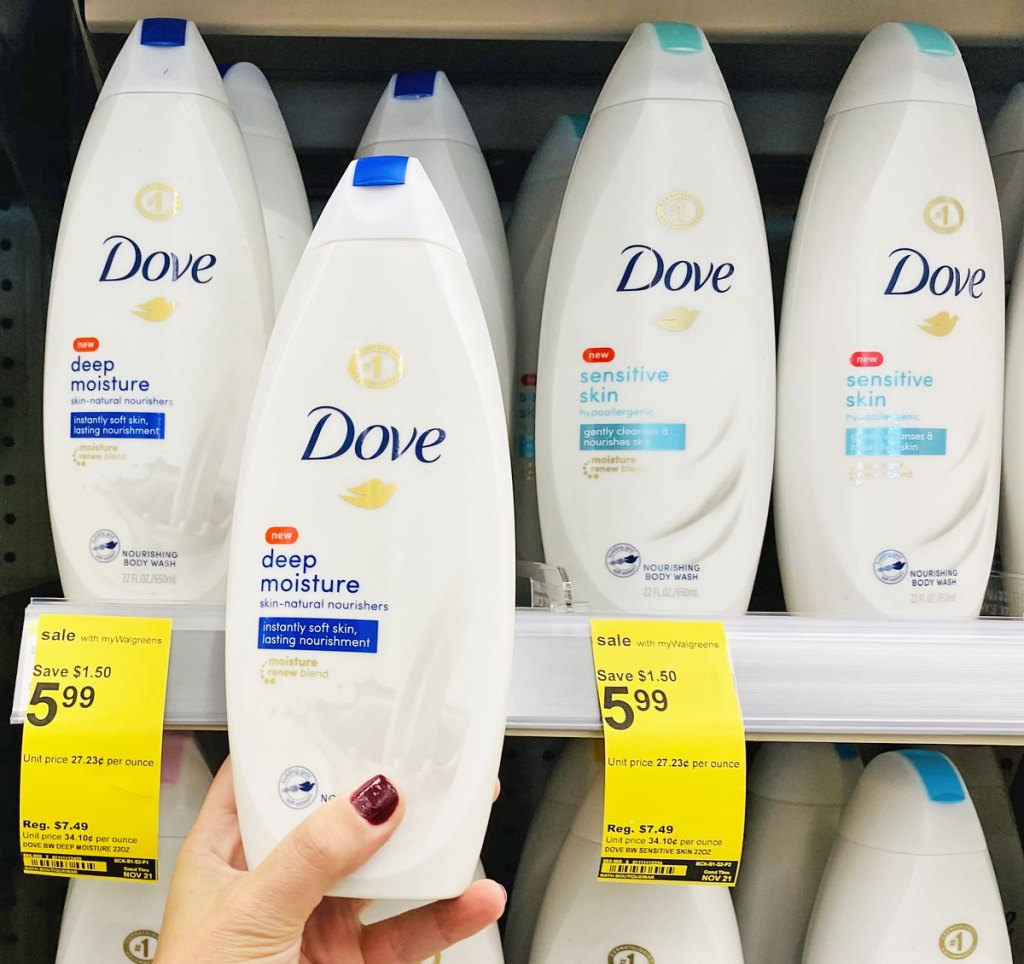 woman with dark red nails holding up a bottle of dove body wash in front of walgreens shelf full of bottles of dove body wash