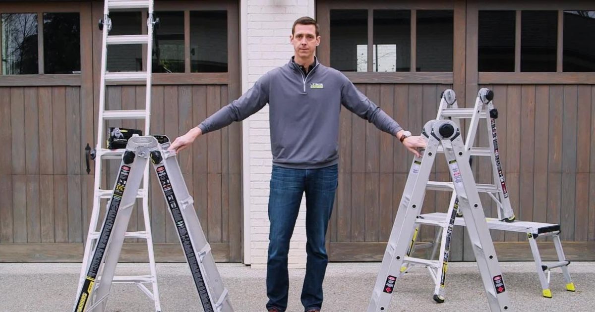 Man with four Gorilla eighteen foot ladders in front of garage doors