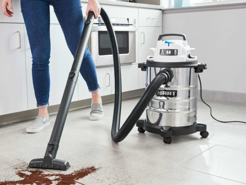 Hart brand wet/dry vacuum cleaner being used to clean up dirt on kitchen floor