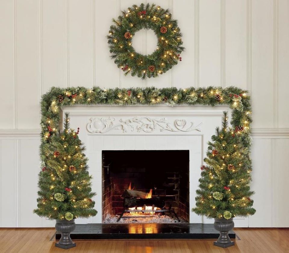 wreath, garland and trees by a fireplace