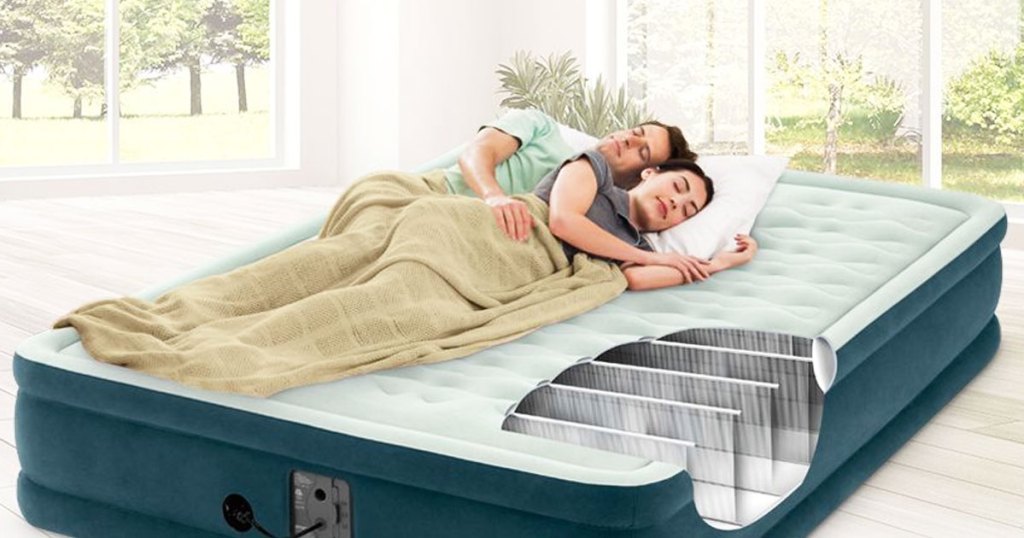 two people sleeping on a green queen size inflatable mattress