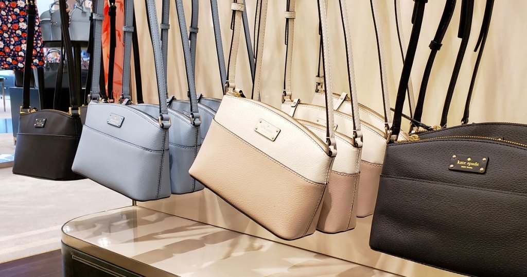 various colors of kate spade crossbody bags on display at store