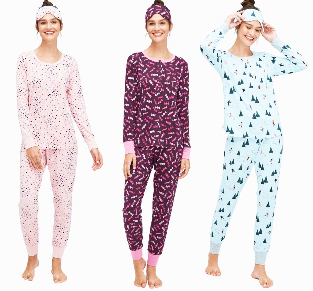 three women wearing printed pajama sets with logger pants, long sleeve henley tops, and matching sleep masks on their heads