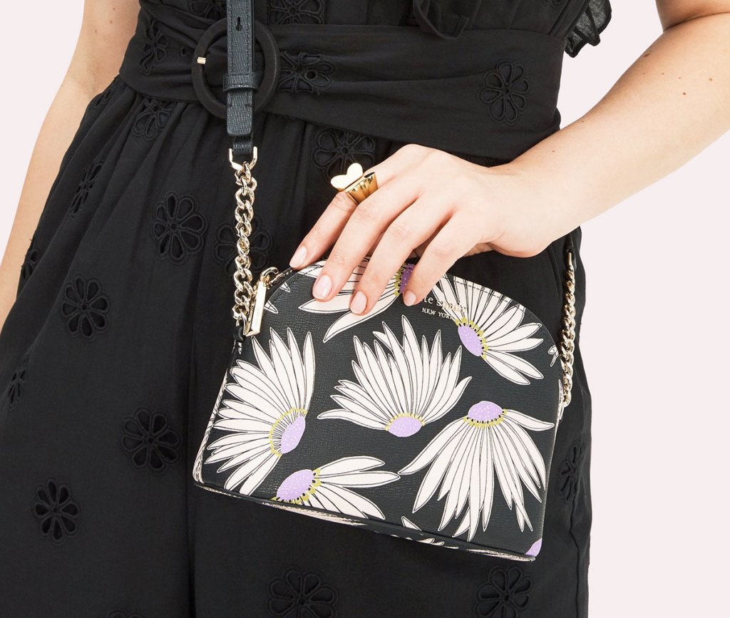 woman in black dress with a dome shaped crossbody with white flower print