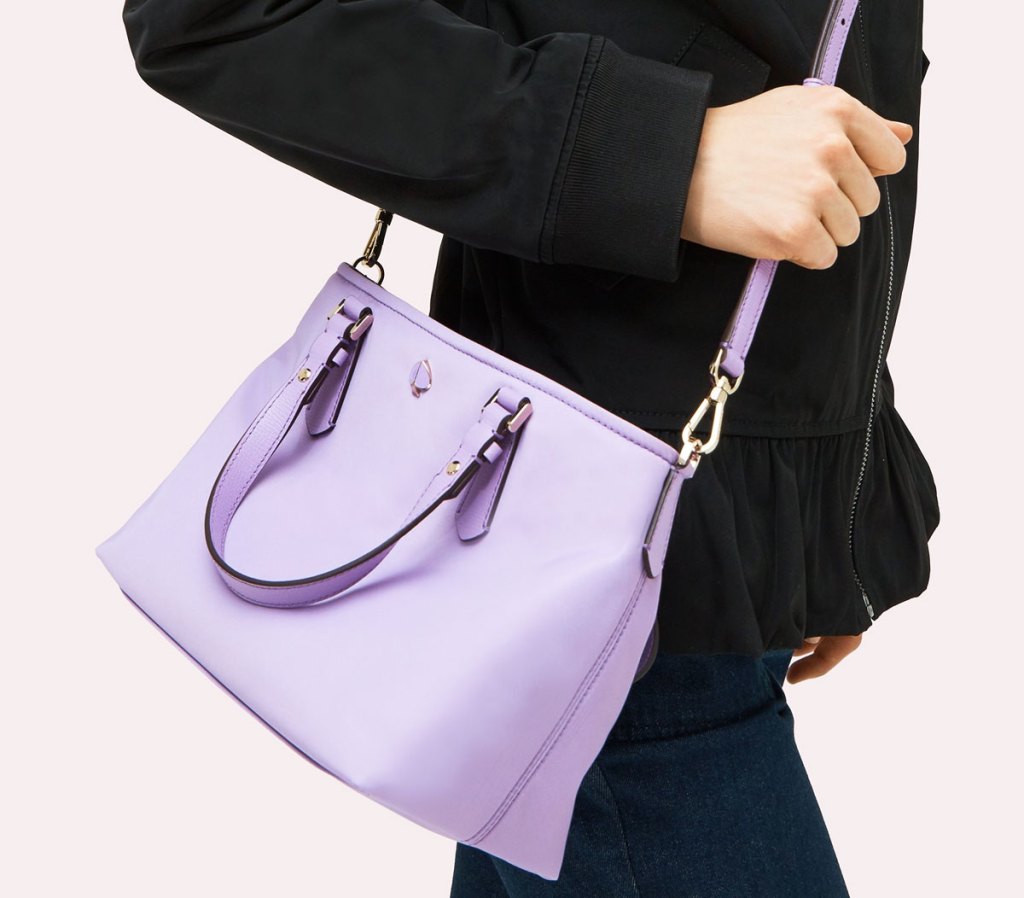 woman in black jacket with a lilac colored kate spade crossbody tote