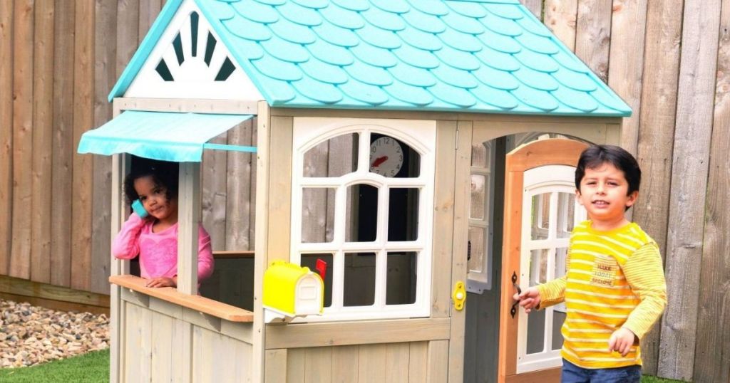 2 kids playing in a kidkraft ocean playhouse