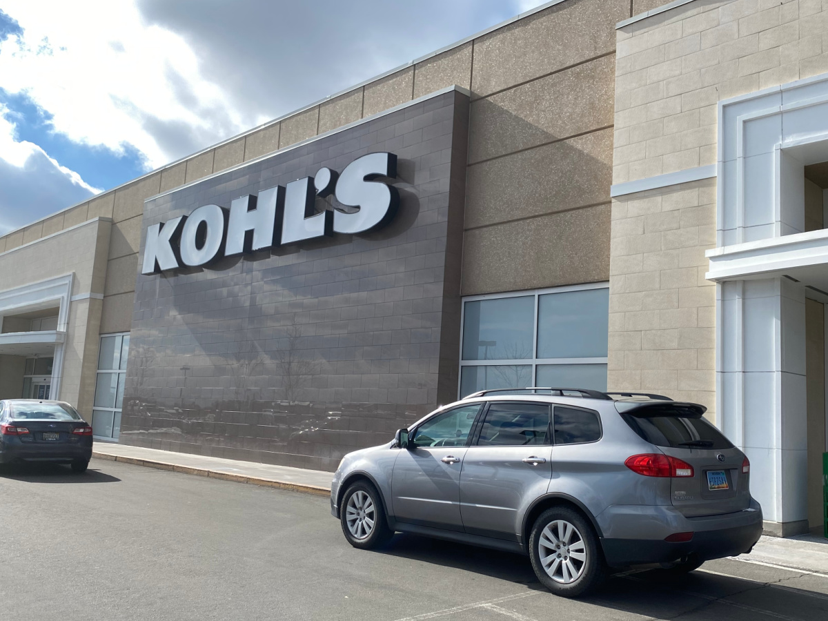 car parked outside a kohl's store next to a curb