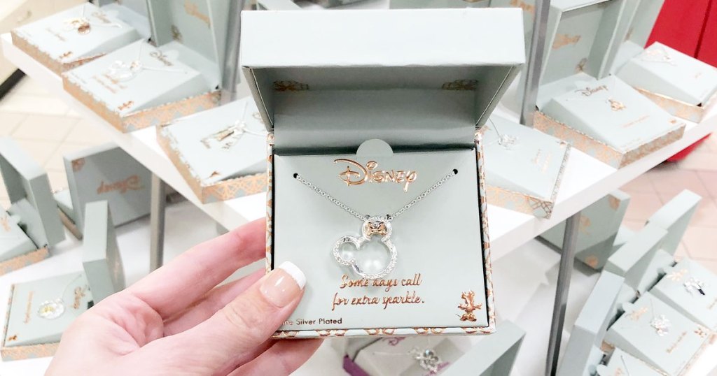 woman holding up silver minnie mouse necklace in silver jewelry box