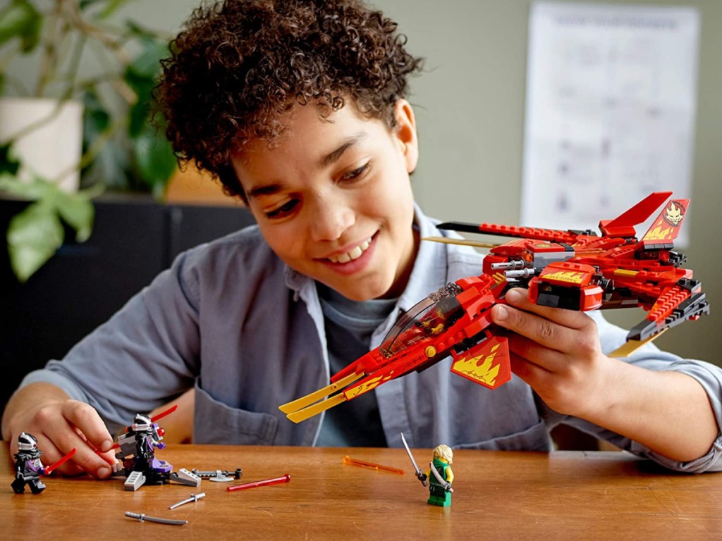 boy playing with LEGOs at table