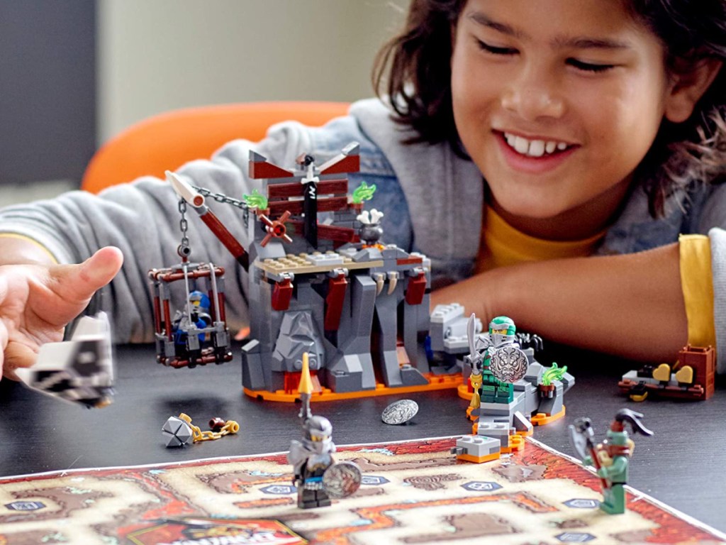 boy smiling while playing LEGOs