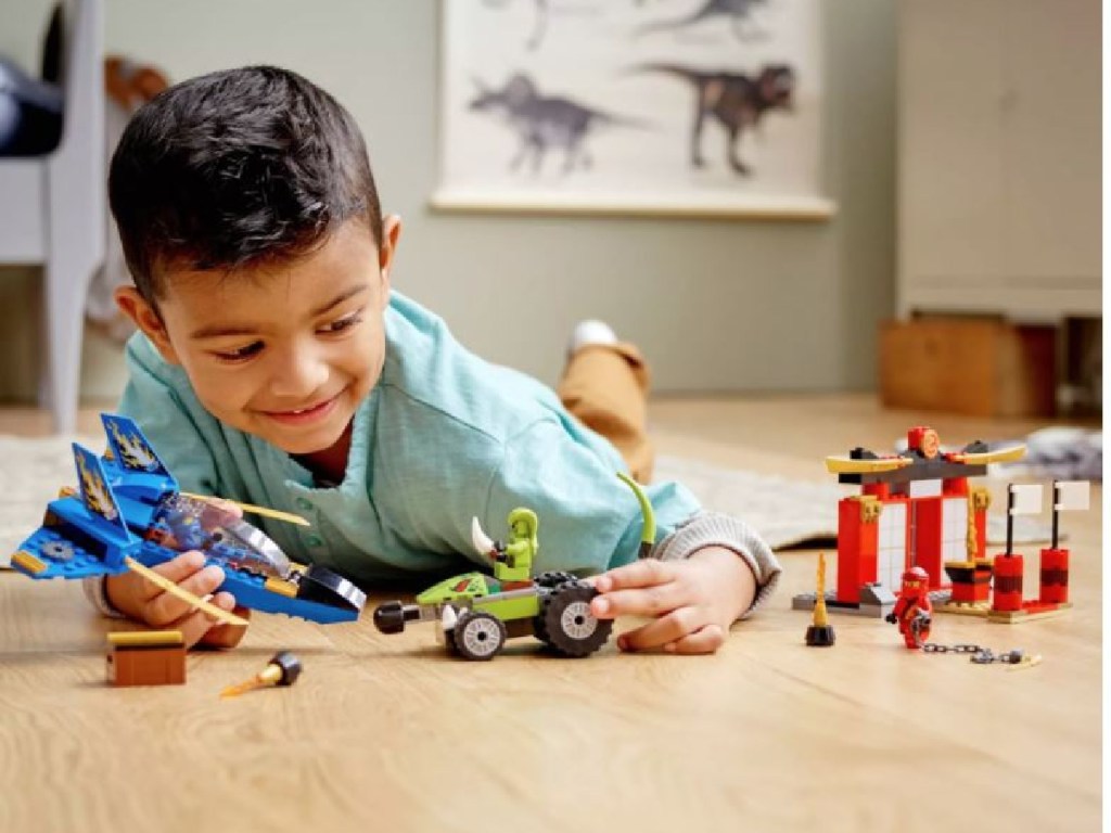 little boy playing with LEGOs on floor