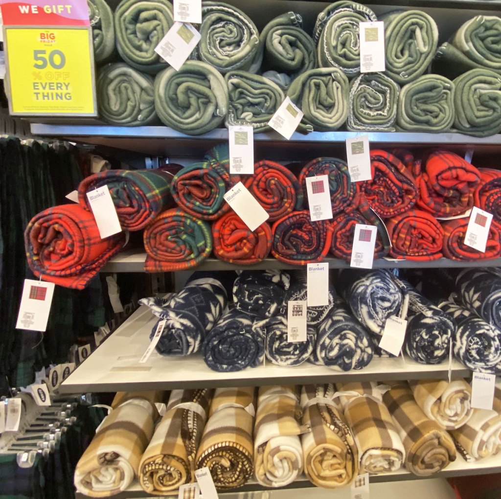 rolled up fleece blankets in a variety of prints on shelves at old navy