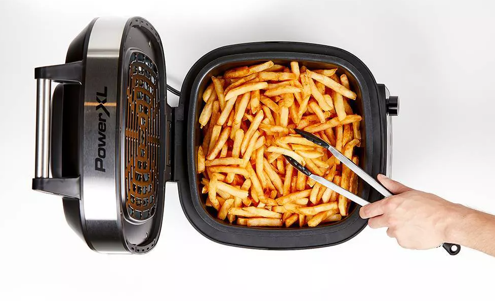 hand taking french fries out of an air fryer