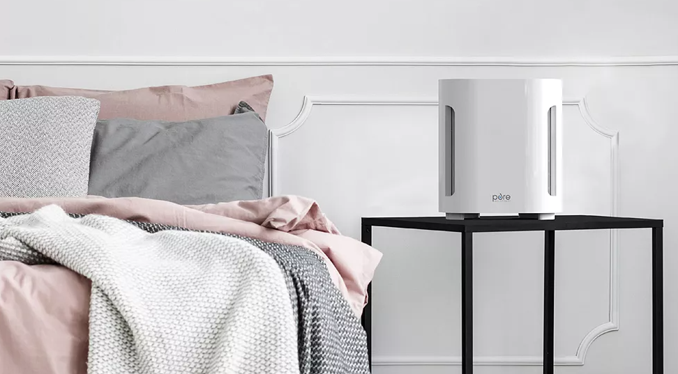 bed with a side table and air purifier