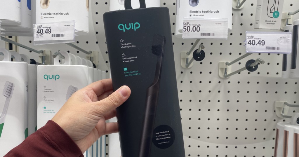 hand holding an all black quip toothbrush at target